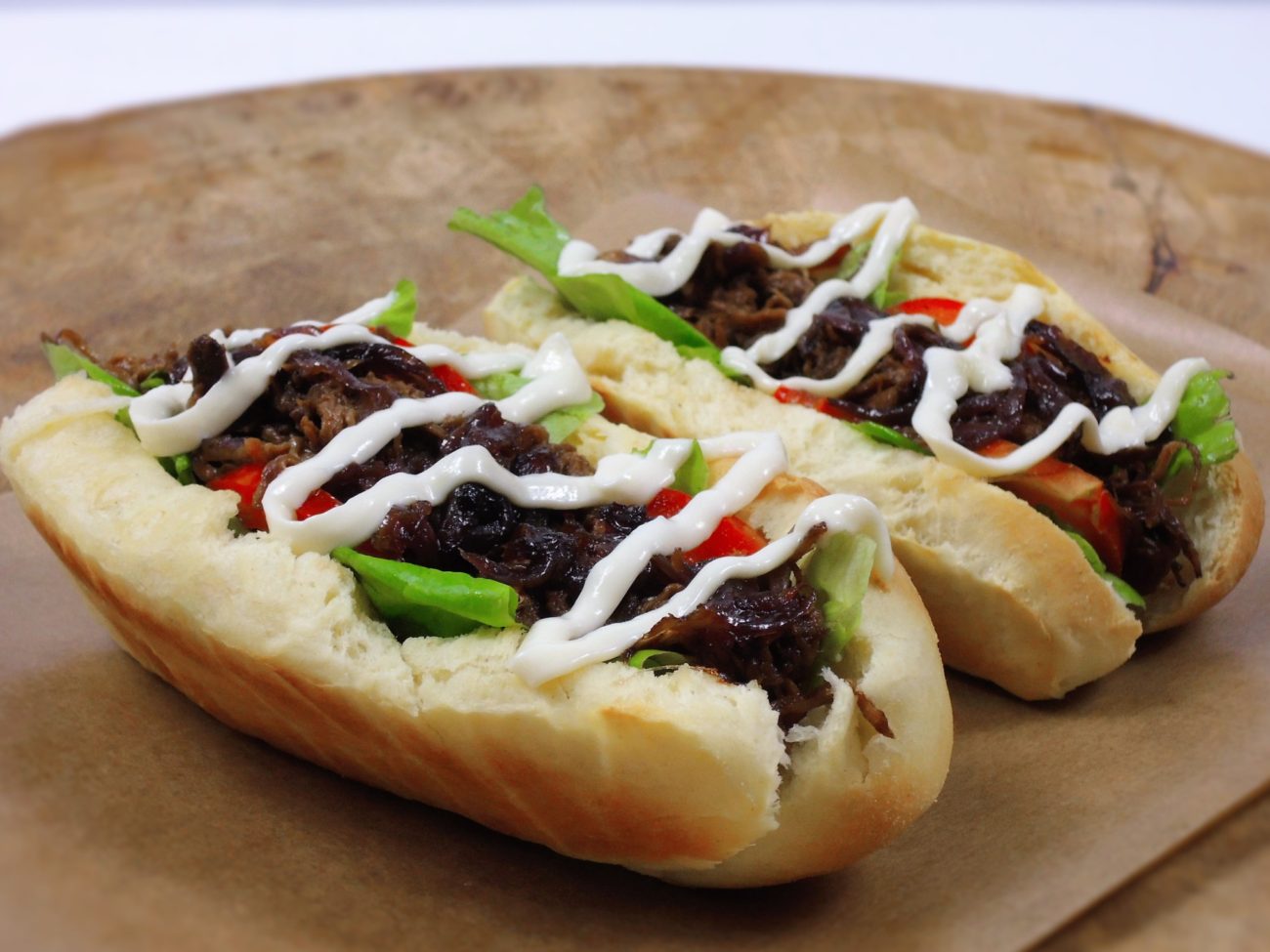 Hotdog s trhaným hovězím masem a karamelizovanou cibulí
