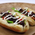Hotdog s trhaným hovězím masem a karamelizovanou cibulí